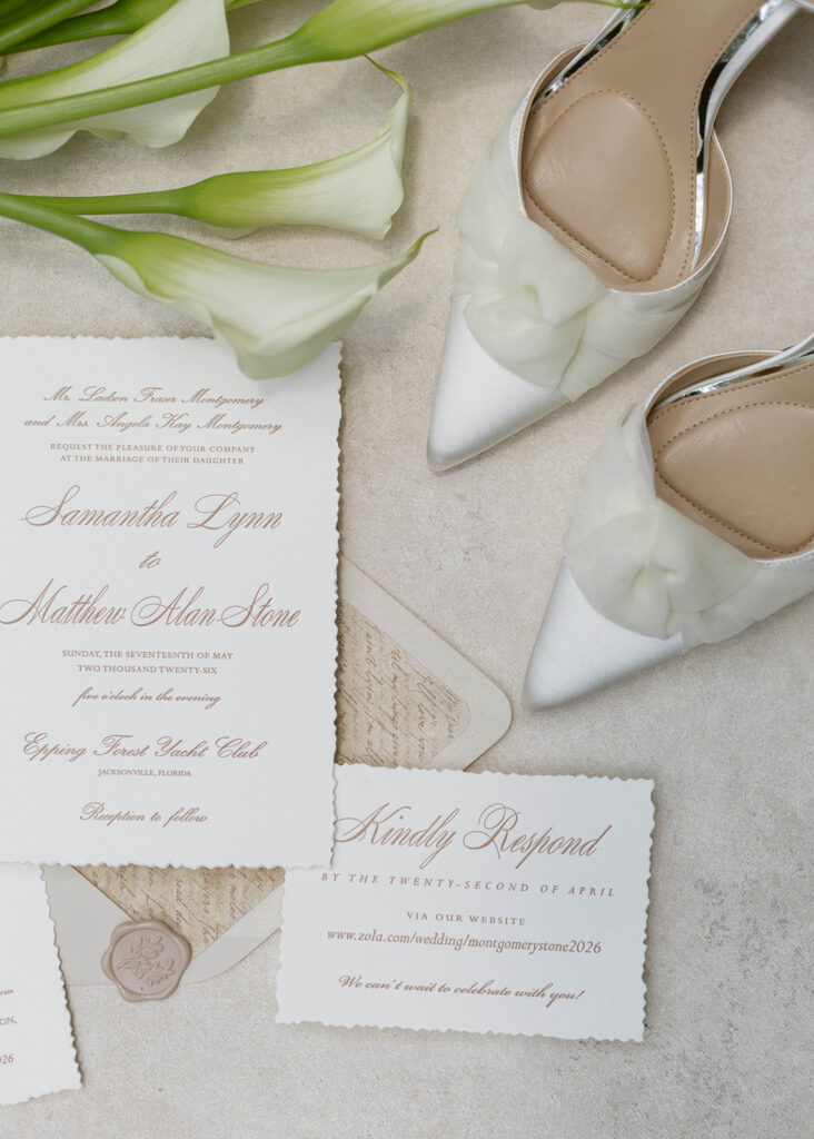 Wedding invitation suite with calligraphy, calla lily bouquet, and rings at Epping Forest Yacht & Country Club