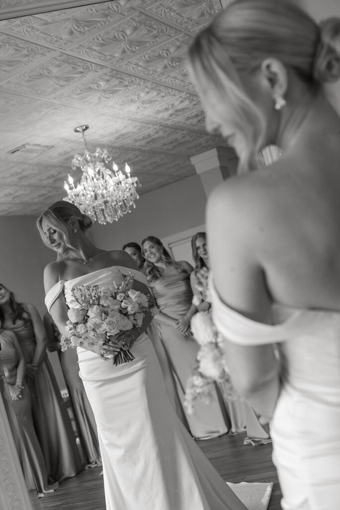 Bride surrounded by bridesmaids under a chandelier before her St. Augustine, Florida wedding