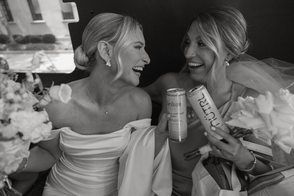 Bride laughing with a bridesmaid while getting ready for her St. Augustine wedding