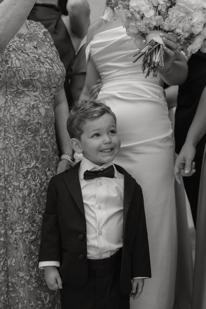 Close-up of the ring bearer smiling next to the bride's bouquet, St. Augustine wedding