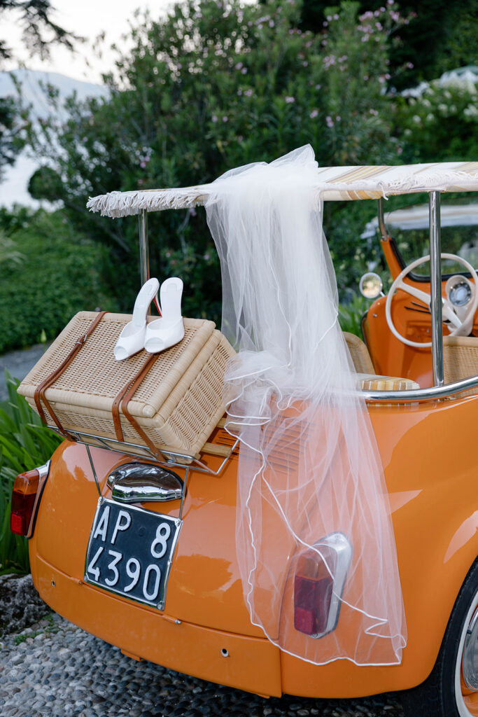 Vintage three-wheeled car packed for the elopement getaway, veil and shoes