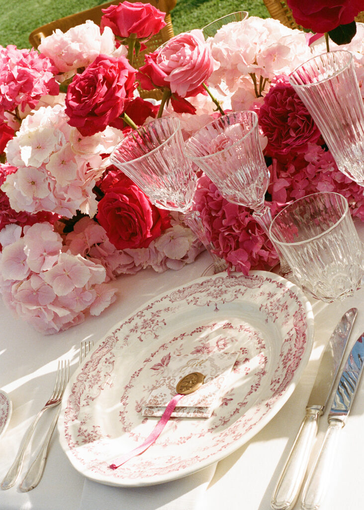 Pink and red floral centerpiece with vintage china place setting