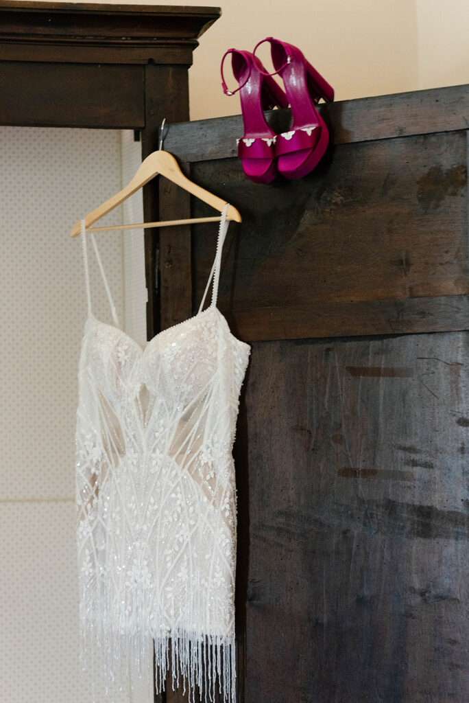 Pink satin heels and wedding gown hanging on a wooden door, Villa Cimbrone wedding