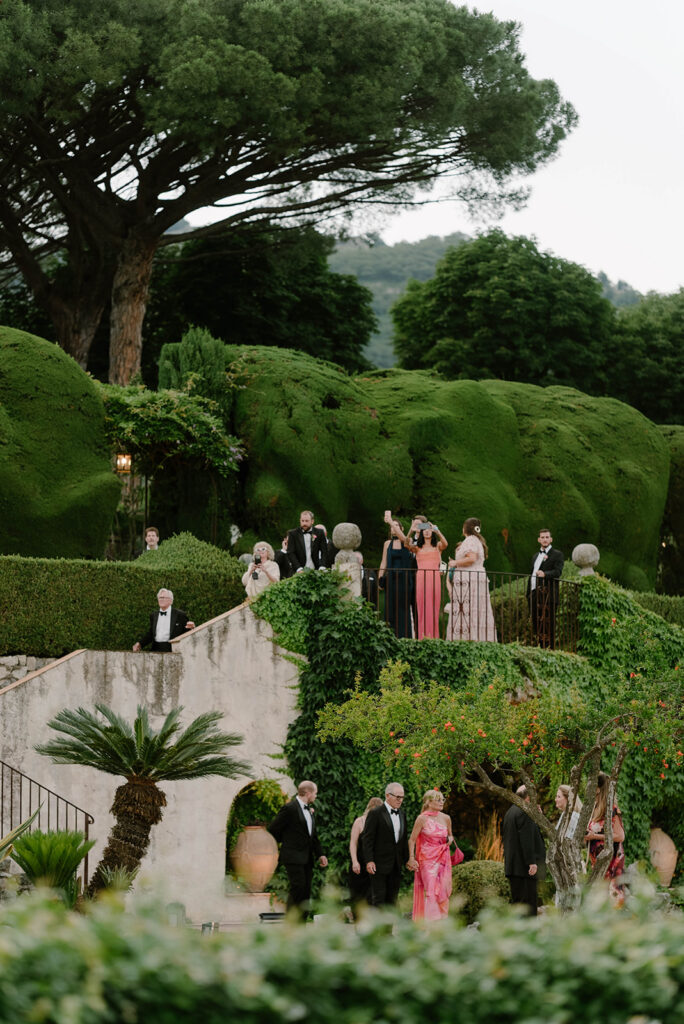 Guests descending a garden staircase between manicured hedges at Villa Cimbrone