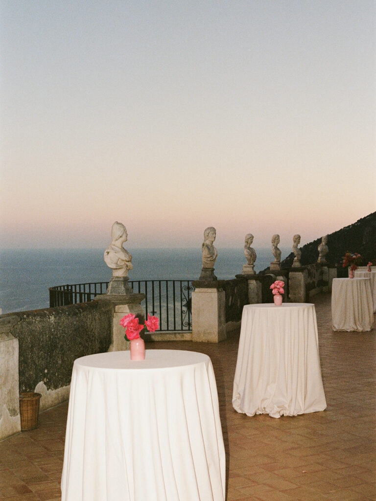 Cocktail hour high-top tables set with white linens on the Villa Cimbrone terrace