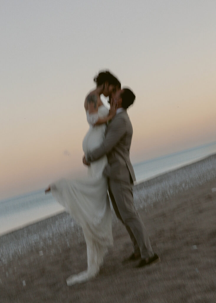 Groom carrying his bride along the beach at sunset, Rhodes, Greece wedding