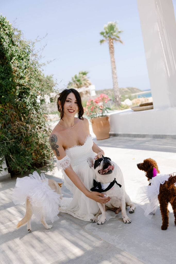 Bride laughing with her dog in a whitewashed courtyard before her Rhodes wedding