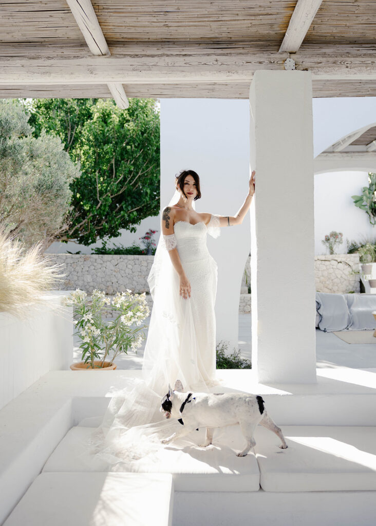 Bride posing on a whitewashed terrace with her dog, Rhodes, Greece wedding