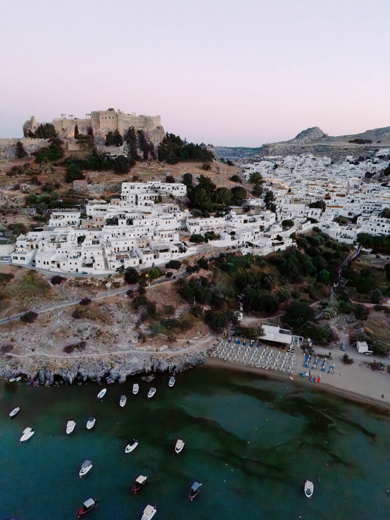 Aerial view of the whitewashed village of Lindos, Rhodes with boats in the harbor