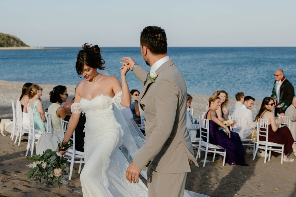 Bride and groom dancing together on the beach after their Rhodes wedding ceremony