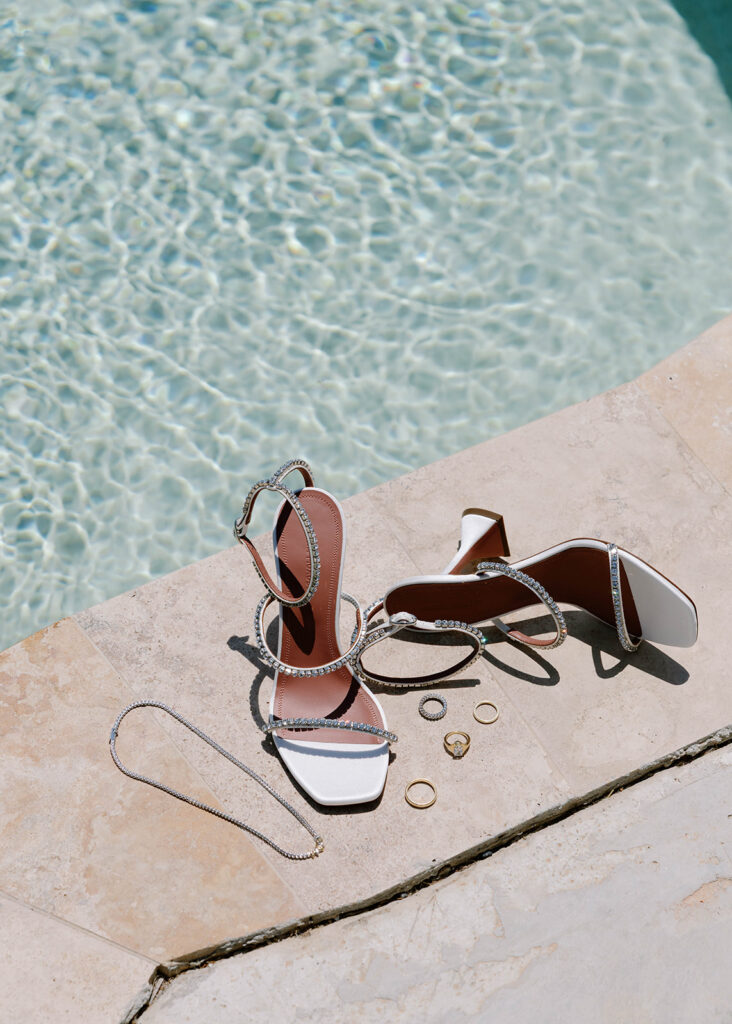 Bridal sandals, sunglasses, and jewelry flat lay poolside, Rhodes, Greece wedding
